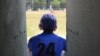 A Cuban baseball player watches action on the field at the 50th Anniversary Stadium in Cuba. 