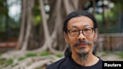 中国劳工权益活动人士韩东方在六四事件32周年之际在香港维多利亚公园外拍照。（2021年6月4日）