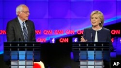 13일 밤 미국 서부 라스베가스에서 열린 민주당 대선 예비후보 TV 토론회에서 버니 샌더스 상원의원(왼쪽)이 힐러리 클린턴 전 국무장관의 발언을 듣고 있다.