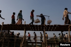FILE - Rohingya refugees cross two bridges at Kutupalong refugee camp, near Cox's Bazar, Bangladesh, Nov. 28, 2017.