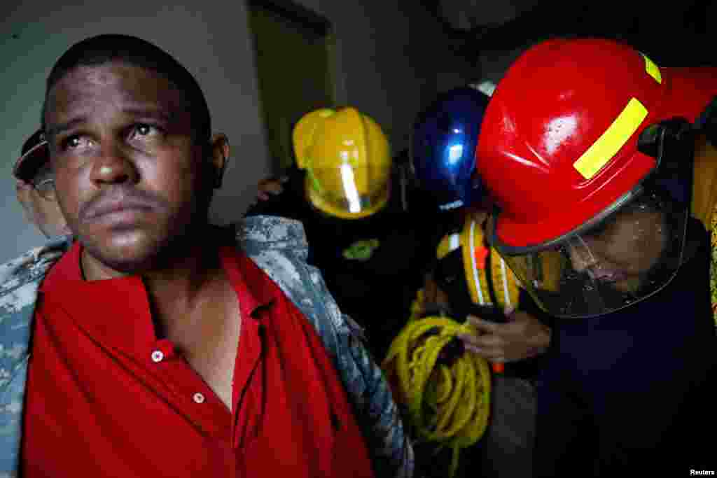 Rescue workers pray before walking out from the Emergency Operation Centre after the area was hit by Hurricane Maria in Guayama, Puerto Rico, Sept. 20, 2017.