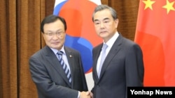 18일 중국을 방문한 한국의 이해찬 중국 특사와 왕이 중국 외교부장이 베이징 외교부에서 만나 악수를 하고 있다.