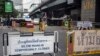 A sign indicating the closure of a main touristic road can be seen next to barricades of anti-government protesters near a main stage of the protest in Bangkok, Feb. 5, 2014. 