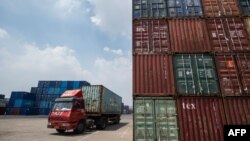 2018年8月7日，中国江苏省张家港港口堆放着集装箱，一辆卡车运输集装箱，在旁边开过。