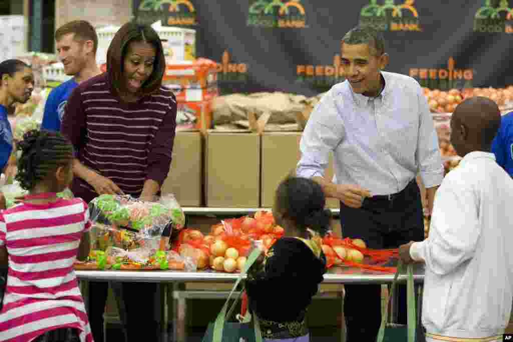 Presiden AS Barack Obama dan Ibu Negara Michelle Obama berpartisipasi dalam program layanan Thanksgiving dengan membagikan makanan bagi warga yang tidak mampu di sebuah dapur umum di Washington (27/11). (AP/ Evan Vucci)