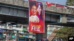 昂山素季和温敏的画像被悬挂在仰光一个交通路口。（2021年2月16日）