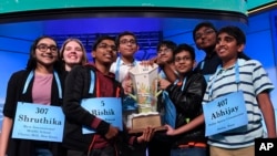 The eight co-champions of the 2019 Scripps National Spelling Bee hold the trophy at the end of the competition in Oxon Hill, Md., May 31, 2019.