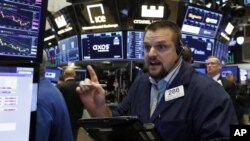 纽约证券交易所的一名交易员。因大公司公布了令人失望的业绩，三大股指开盘普遍走低，此前一天股市大幅飙升。（2018年10月26日）