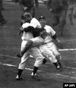 In this Oct. 8, 1956 photo, New York Yankees catcher Yogi Berra is embraced by pitcher Don Larsen as he leaps into Larsen's arms at the end of Game 5 of baseball's World Series against the Brooklyn Dodgers at New York's Yankee Stadium.