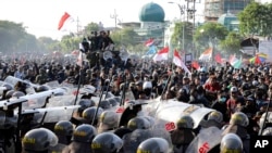 Riot police officers block students from advancing toward the local parliament during a rally in Surabaya, East Java, Indonesia, Sept. 26, 2019. 
