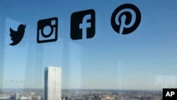 资料照：一扇玻璃窗上显示的推特、脸书等社交媒体的标识。