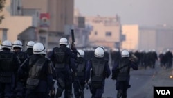 Polisi anti huru-hara Bahrain mengejar para demonstran anti-pemerintah di kawasan Muslim Shiah di Sitra, Bahrain (1/1).