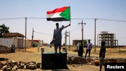 Un manifestant soudanais porte un drapeau national, exigeant que le Conseil militaire de transition transfère le pouvoir aux civils, à Khartoum (Soudan), le 5 juin 2019.
