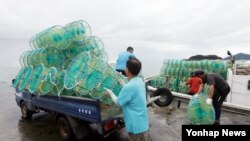 북한의 서부전선 포격 도발로 중단됐던 서해 5도 조업이 재개된 26일 인천시 옹진군 연평면 당섬부두 선착장에서 어민들이 꽃게잡이 통발을 어선에 싣고 있다. 
