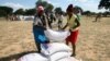 FILE - Villagers queue to collect their monthly food aid ration of cereals at a school in drought-hit Masvingo, Zimbabwe, June 2, 2016. 
