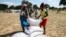 FILE - Villagers queue to collect their monthly food aid ration of cereals at a school in drought-hit Masvingo, Zimbabwe, June 2, 2016. 