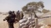 FILE - Cameroonian soldiers guard against Boko Haram militants on Elbeid bridge near the village of Fotokol, on the border with Nigeria's Borno state. Militant attacks have fed demand for private security firms, now the focus of a government clampdown.