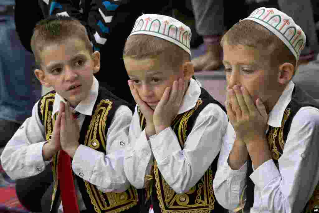 ក្មេងៗ​ធ្វើការ​បួងសួង​នៅ​អំឡុងពេល​ពិធី​បុណ្យ Eid al-Adha ខាង​ក្រៅ​វិហារ Sultan Mehmet Fatih ក្នុង​ក្រុង​ព្រីស្ទីនណា ប្រទេស​កូសូវ៉ូ។&nbsp;