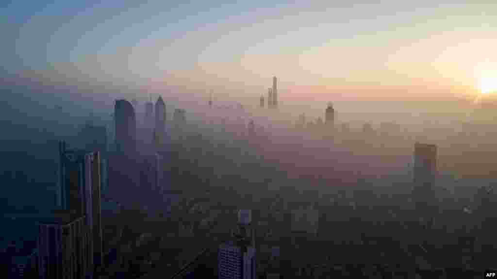 2018年2月23日，上海空气污染较重，太阳升起，照耀高楼大厦。