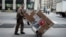 FILE - A UPS delivery man is seen pushing a trolley of packages in New York City.