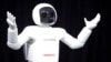 FILE - Honda Motor's Asimo robot puts on a demonstration for the media at the Jacob Javits Convention Center during the New York International Auto Show in New York, April 17, 2014. 