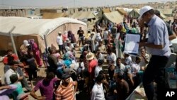 지난 13일 이라크 북부 다쿠르의 난민 난민촌에 서, 식량 지원을 받기 위해 모여든 시리아 난민들.