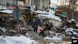 土耳其城市马拉蒂亚的地震灾民坐在房屋废墟上。 （2023年2月7日）