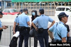 2019年7月7日警察在西九龙高铁车站外对一名行人进行盘查 （美国之音记者申华拍摄）