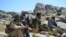 FILE - Afghan resistance movement and anti-Taliban uprising forces rest as they patrol on a hilltop in Darband area in Anaba district, Panjshir province, Sept. 1, 2021. 
