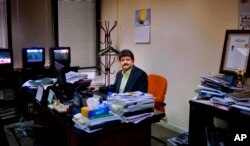 FILE - Pakistani journalist Hamid Mir sits in his office in Islamabad, Pakistan. Perhaps the most popular of Pakistan's news anchors, Mir, says both media owners and journalists operate under a cloud of fear, March 14, 2017.