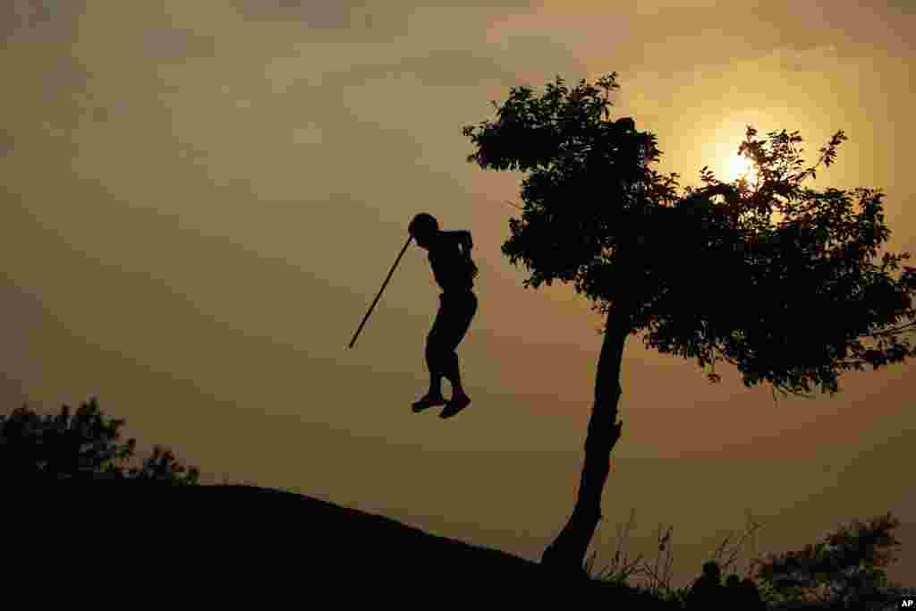A Nepalese boy jumps from a tree in Kathmandu.