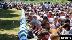Sejumlah pria muslim Bosnia berdoa dalam acara pemakaman massal sisa jasad korban pembantaian Srebenica di Potocari, Bosnia Herzegovina, pada 11 Juli 2024. (Foto: Reuters/Amel Emric)