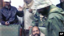A mobile phone picture taken by one of his guards shows Saif al-Islam Gaddafi sitting with his captors in Obari airport November 19, 2011