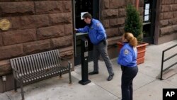 New York Police community affairs officers enter the HI New York City Hostel, Dec. 5, 2024, in New York, where police say the suspect in the killing of UnitedHealthcare CEO Brian Thompson may have stayed.