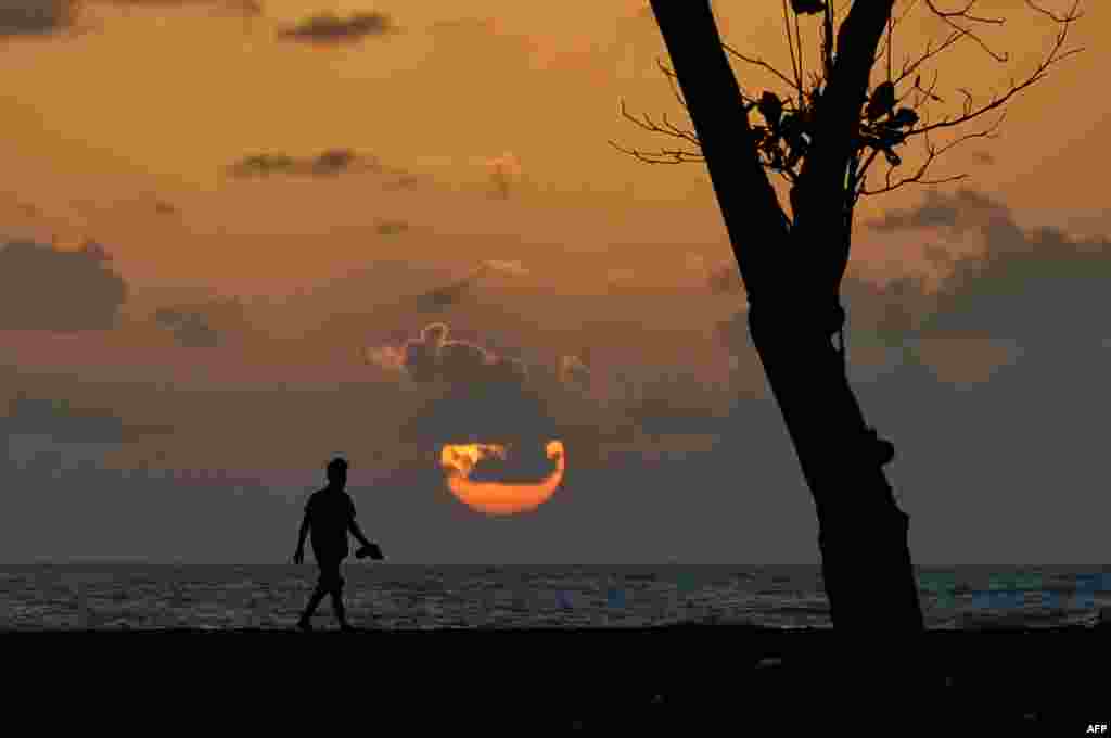 Seorang pria Aceh memandang matahari terbenam di pantai Meulaboh di provinsi Aceh, Indonesia.