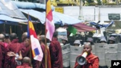 身穿蕃红色袈裟的缅甸僧侣与军警对峙