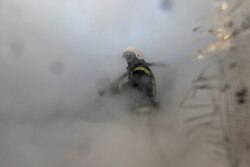 អ្នកពន្លត់អគ្គិភ័យម្នាក់កំពុងព្យាយាមពន្លត់អគ្គិភ័យដែលបានឆាបឆេះសំណង់អគារលំនៅដ្ឋានរបស់ពលរដ្ឋ ដោយសារតែការបាញ់ផ្តក់របស់ទាហានរុស្ស៊ីនៅទីក្រុងកៀវ ប្រទេសអ៊ុយក្រែន ថ្ងៃទី ២៣ ខែមីនា ឆ្នាំ ២០២២។