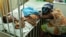 Hassana Ousmane rests her head against the bed where her 21-month-old daughter, Zeinab, suffering from malaria, rests at the Princess Marie Louise Children's Hospital in Accra, Ghana, April 25, 2012.