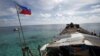 FILE - A Philippine flag flutters a dilapidated Philippine Navy ship that has been aground since 1999 and became a Philippine military detachment on the disputed Second Thomas Shoal, part of the Spratly Islands, in the South China Sea, March 29, 2014.