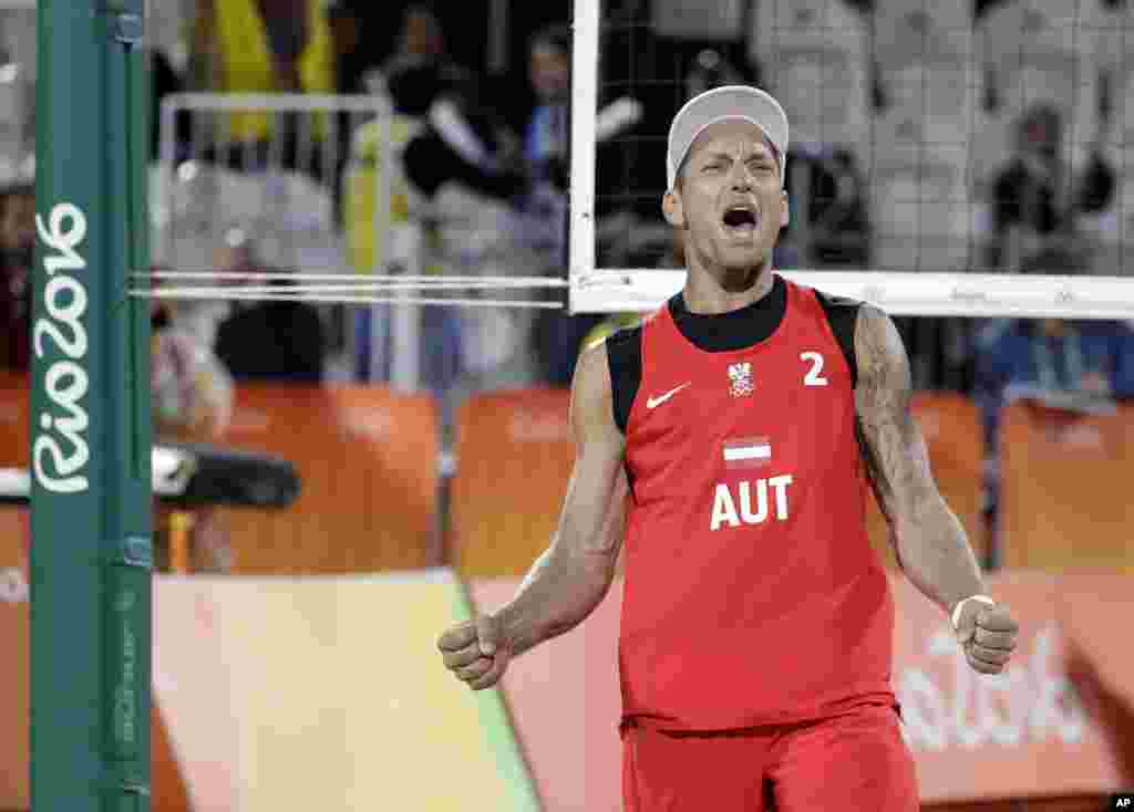 Alexander Horst dari Austria merayakan kemenangan atas Kanada dalam pertandingan bola voli pantai putra (11/8). (AP/Marcio Jose Sanchez)