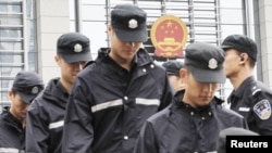 Penjagaan ketat dikerahkan di sekitar gedung pengadilan Hefei di propinsi Anhui (10/8). Empat pejabat kepolisian Tiongkok diadili atas tuduhan berupaya membantu istri Bo Xilai menutupi pembunuhan seorang pengusaha Inggris.