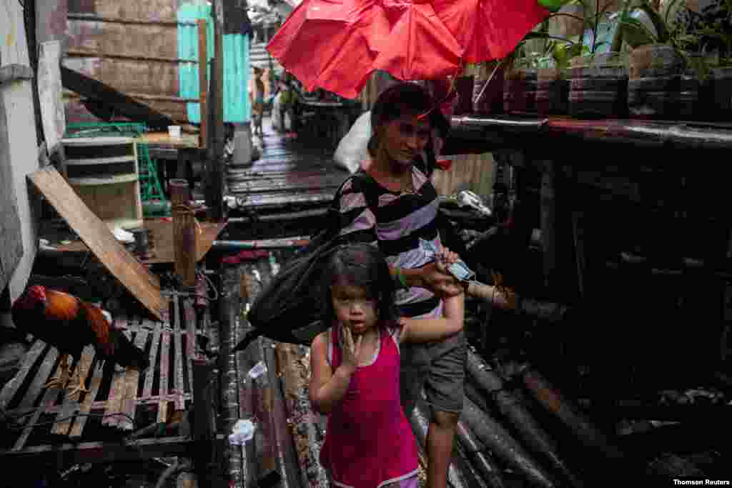 태풍 밤꼬가 필리핀 마닐라 지역을 향해 접근하는 가운대 한 여성이 아이와 대피하고 있다. 