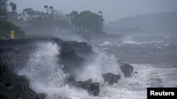 ຄ​ື້ນ​ທະ​ເລ​ສູງ​ພັດ​ເຂົ້າ​ໃສ່​ກັນ​ເຈື່ອນຢູ່​ຕາມ​ແຄມ​ຝັ່ງ​ທະ​ເລ ໃນ​ຂະ​ນະ​ທີ່​ພາ​ຍຸໄຕ້​ຝຸ່ນ ຊານ​ຊານ ຫຍັງ​ໃກ້​ກັບ​ແຂວງ ອິ​ບາ​ຣາ​ກິ ຂອງ ຍີ່​ປຸ່ນ.