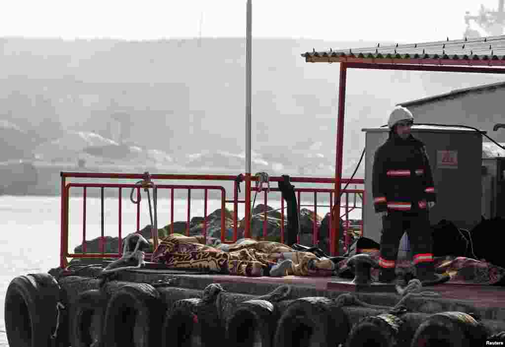 A rescue worker walks past bodies retrieved from the sea after a boat sank in the Bosphorus strait, near Istanbul, Turkey, Nov. 3, 2014. 