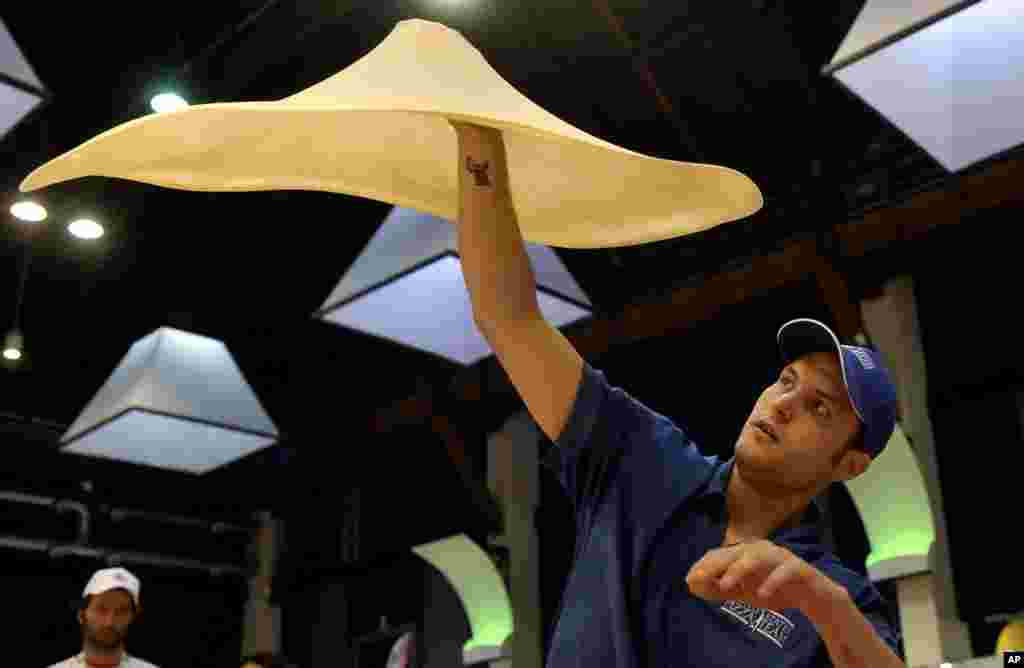 Pembuat pizza, Bradley Johnson menunjukkan keahliannya pada kejuaraan dunia Pizza di kota Parma, Italia.