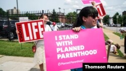 FILE - Abortion rights and anti-abortion rights protesters stand outside Planned Parenthood as a deadline looms to renew the license of Missouri's sole remaining Planned Parenthood clinic in St. Louis, May 31, 2019.