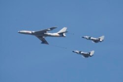 资料照：中国空军一架轰-6和两家歼-10战斗机在北京参加庆祝抗战胜利70周年纪念活动。（2015年9月3日）