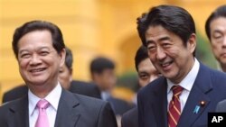 日本首相安倍晋三1月16日在河内与越南总理阮晋勇交谈