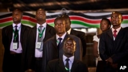 FILE - Security and bodyguards of the election commission chairman stand as he delivers a statement to the media, at the National Election Center.