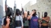 FILE - Masked Sunni gunmen pose during a patrol outside Fallujah, Iraq, April 28, 2014. 